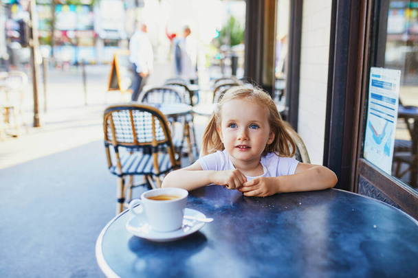Schattig drie jaar oud meisje in Parijse cafe of restaurant. Uitgaan met kinderen concept - Foto, afbeelding