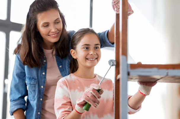 mother and daughter painting old table in grey - Foto, imagen