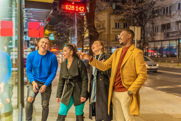 Grupo de multirraciais melhores amigos estão rindo todos juntos na frente da loja - Foto, Imagem