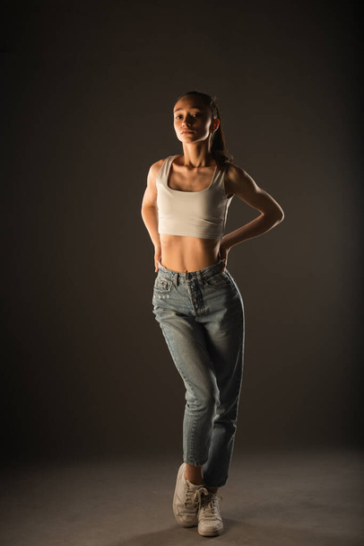 Sweet and skinny girl is posing in studio on grey background - Fotó, kép