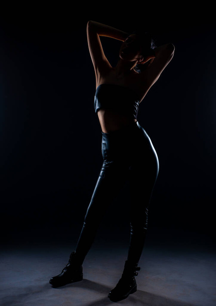 Siluetti houkutteleva tyttö poseeraa studiossa mustalla taustalla - Valokuva, kuva