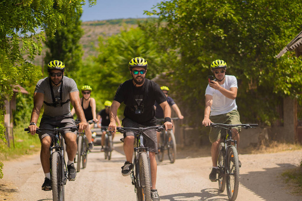 Группа друзей катаются на велосипедах вместе, весело проводя время - Фото, изображение