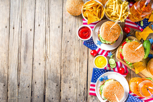 Celebrating Independence Day, July 4. Traditional American Memorial Day Patriotic Picnic with burgers,  french fries and snacks, Summer USA picnic and bbq concept, Old wooden background  - Photo, Image