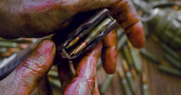 War and death - bloodied hands of a soldier or rebel with automatic magazine with cartridges. - Footage, Video
