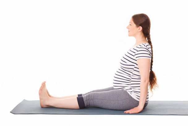 Zwangere vrouw doet yoga asana Dandasana - Foto, afbeelding