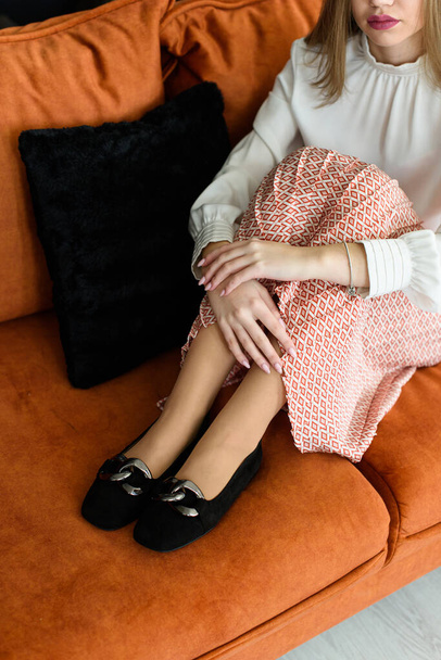 Photo of a womens legs in suede high-heeled shoes with a buckle. Posing on a sofa - Foto, Imagem