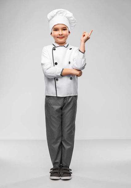 petit garçon dans chefs toque pointant doigt vers le haut - Photo, image
