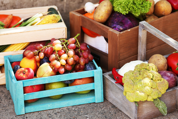 Fresh organic fruits and vegetables in wooden boxes outdoors - Foto, immagini