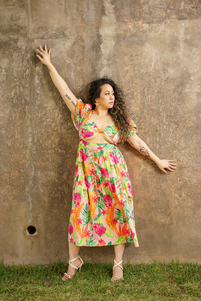 Hermosa mujer posando en una pared de hormigón con los brazos extendidos - Foto, Imagen