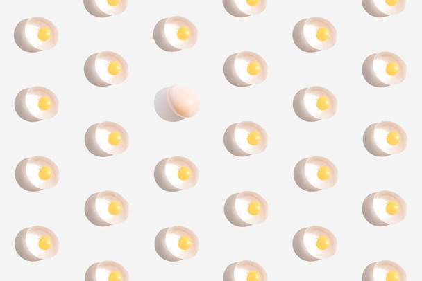 Saumaton trendikäs kuvio muna kanssasuun kuori ja valkoinen tausta. Minimalistinen nykyaikainen tyyli. Pääsiäinen tai ruoka käsite. - Valokuva, kuva