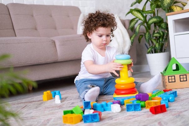 enfant frisé fille jouer avec pyramide et constructeur à la maison. développement de la petite enfance - Photo, image