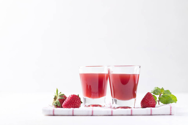 Jahodová šťáva ve sklenici s čerstvým jahodovým ovocem na bílém pozadí, Zdravý nápoj - Fotografie, Obrázek