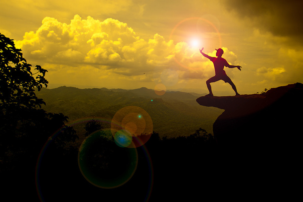 homme debout sur la montagne essayant d'attraper le soleil
 - Photo, image