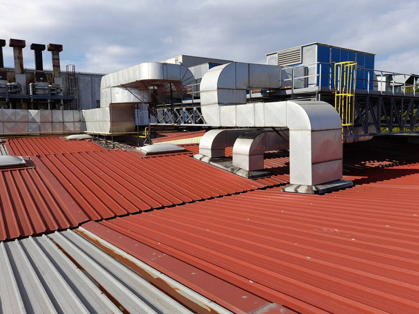 Техническая система на старой крыше промышленного здания из гофрированного листового металла - Фото, изображение
