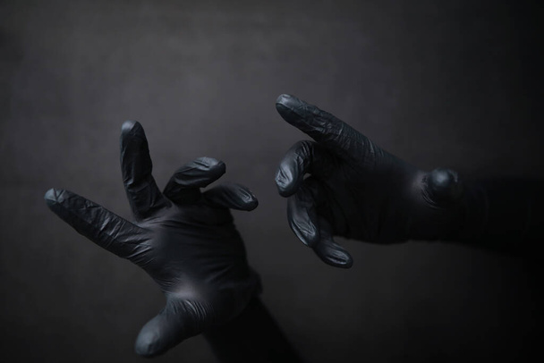Background of hands in gloves. Black gloves. Hand gestures black gloves. - Foto, Bild