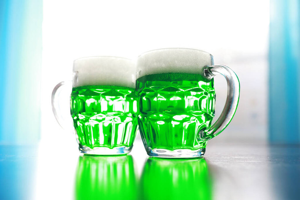 Праздник Святого Патрика. Национальный ирландский праздник. Зеленое пиво. Рука с изумрудным пивом в баре. - Фото, изображение