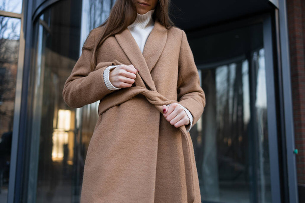 Menina está amarrando um cinto em um casaco - Foto, Imagem