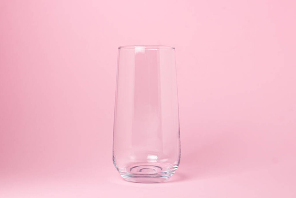 ピンクの背景に空のガラス。ガラス透過カクテルガラス。ガラス製品 - 写真・画像