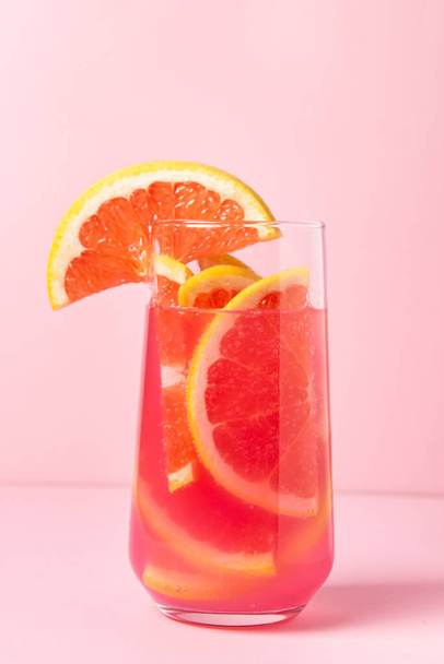 Розовый коктейль с грейпфрутом на розовом фоне. Сладкий фруктовый коктейль. вкусный напиток - Фото, изображение