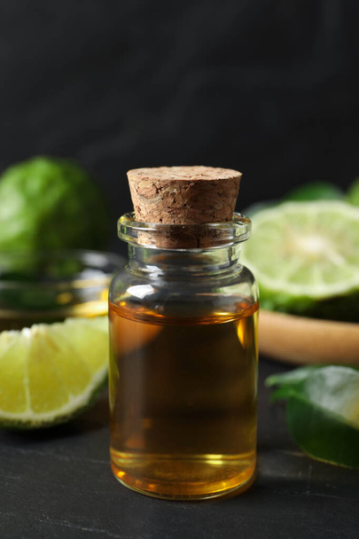 Bottle of bergamot essential oil on dark table, closeup - Foto, afbeelding