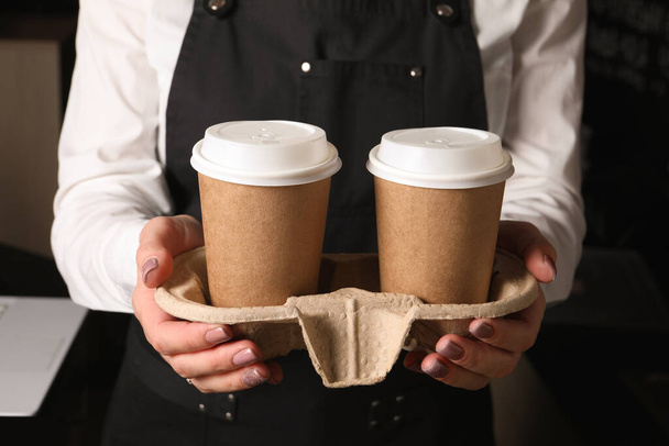 Barista holding takeaway paper cups with coffee in cafe, closeup - Fotografie, Obrázek