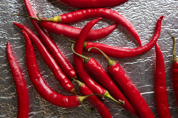 Chili hot peppers in red pattern over silver - Photo, Image