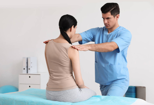 Orthopedist examining woman in clinic. Scoliosis treatment - Foto, imagen