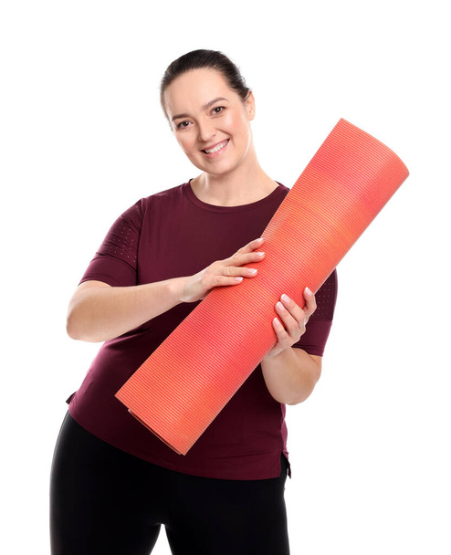 Happy overweight woman with yoga mat on white background - Fotó, kép
