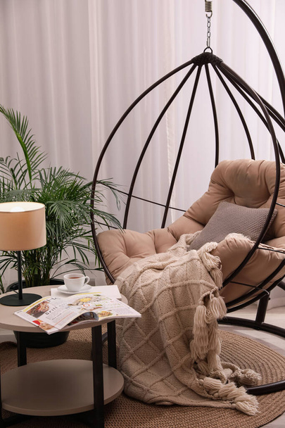 Comfortable place for rest with hanging chair near window in room - Foto, Imagem