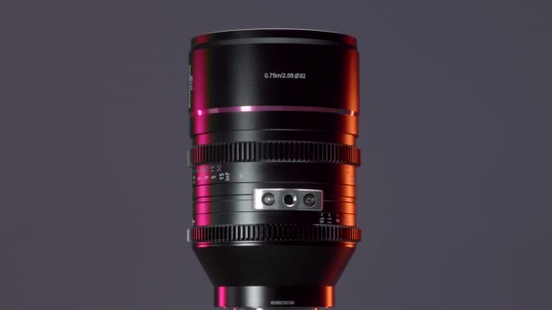  A huge camera lens. Action. A large portrait lens that rotates around itself on a gray background. - Footage, Video