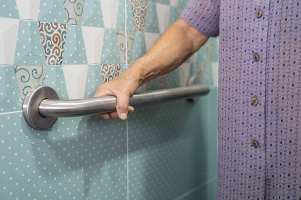 Asiatique senior ou vieille dame femme patient utilisation toilettes salle de bain poignée sécurité dans la salle d'hôpital de soins infirmiers, concept médical fort sain. - Photo, image