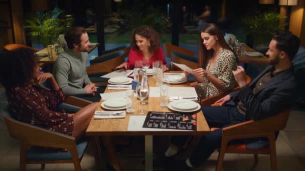Diverse Freunde plaudern bei geselligem Abend über schickes Restaurant-Treffen. - Filmmaterial, Video