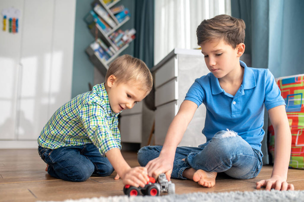 Two kids playing with their toy vehicles - Fotoğraf, Görsel