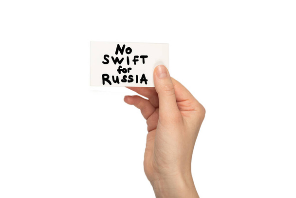 女性の手で白い背景に隔離されたカード上のロシアのテキストのためのSWIFTはありません. - 写真・画像
