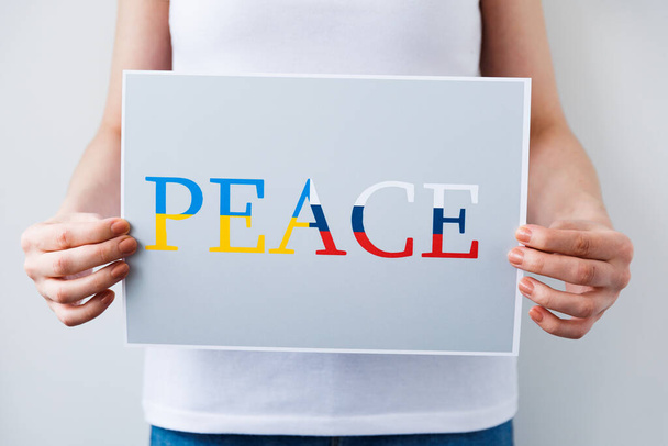 close up of a Protester hands holding cardboard Banner with the words peace. - Photo, Image