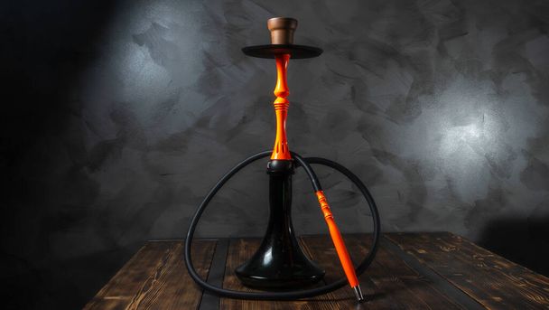 Modern orange hookah on a gray concrete abstract background. - Photo, image