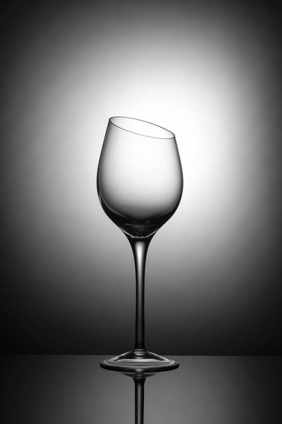 Glazen beker met schuine bovenrand op een witte achtergrond in vignet - Foto, afbeelding