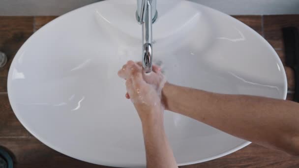 Close-up männliche Hände waschen in großen weißen Waschbecken zu Hause im Badezimmer im Hotel tägliche Hygiene Körperpflege Mann waschen Handwäsche Handflächen reinigt Bakterien Coronavirus Ausbruch Prävention im Hotelzimmer - Filmmaterial, Video