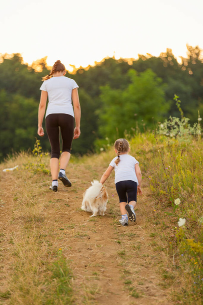 mother, daughter and dogs run - Foto, Bild