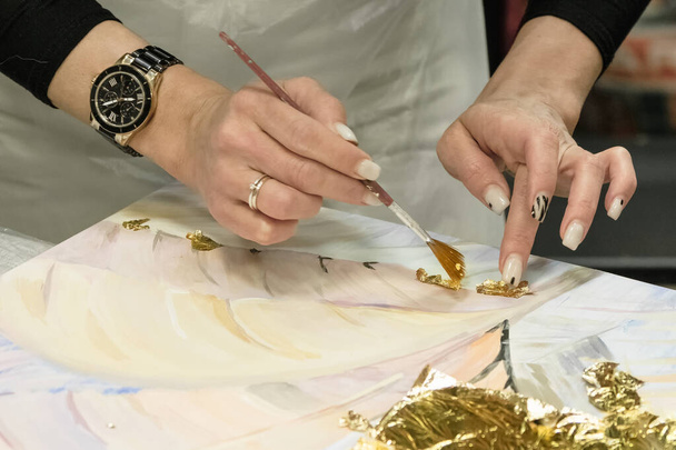Selective focus. Handmade technique of applying the gold leaf. Gold gilding leaf decoration with brush, close up. - Photo, Image