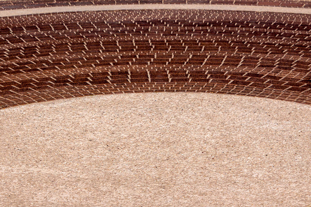 Piazza della città. La combinazione di arenaria beige con un bordo di mattoni marroni. Posto per un'iscrizione (annuncio) con una spettacolare bordatura ad arco. Texture. - Foto, immagini