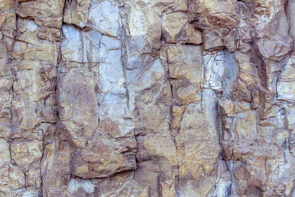Steep mountain slope with signs of erosion. Natural stone of beautiful shades. Fragment, texture. - Photo, Image