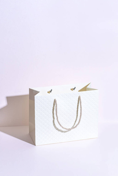 Elegante borsa di cartone beige con una stringa su sfondo viola - Foto, immagini