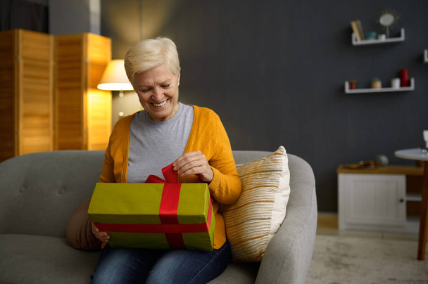 Mujer mayor sosteniendo regalos paquete de caja de regalo - Foto, Imagen