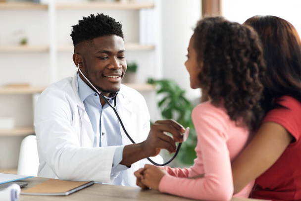 Black man doctor listening to child patient breath with stethoscope - Foto, Bild