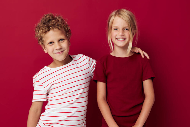 Cute preschool kids smiling and posing in casual clothes against red background - Valokuva, kuva