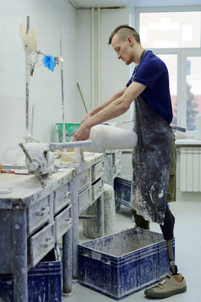 Mladý současný pracovník vyrábějící protézu v dílně - Fotografie, Obrázek