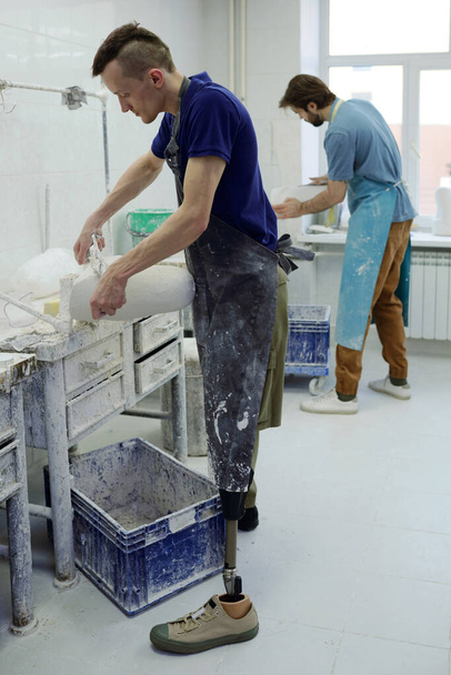 Mladý pracovník současné protetické továrny broušení omítky odlité - Fotografie, Obrázek