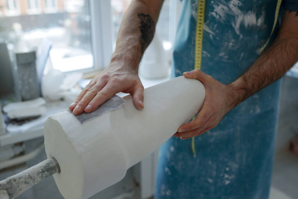 Mãos de jovem trabalhador contemporâneo polimento gesso moldado com lixa - Foto, Imagem