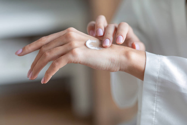 Dry Skin Remedies. Unrecognizable Female Applying Moisturizing Cream On Hands - Photo, Image